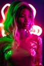 Stylish sexy African woman looking at side in pink and green lights with neon unusual backlit. Young woman with ombre