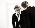 Stylish man checking his hairstyle in mirror Royalty Free Stock Photo
