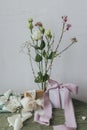 Stylish simple gift with silk ribbons and modern bouquet against rustic wall. Happy women\'s day and mother\'s day