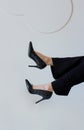 Stylish slim women feet in black high heels. Female legs in pants on white background. Elegant shoes fashion for woman Royalty Free Stock Photo