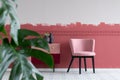 Stylish small pastel pink chair next to trendy pink and burgundy commode