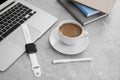 Stylish smart watch, laptop and cup of coffee on grey marble table Royalty Free Stock Photo