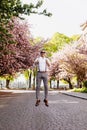 Stylish smiling young man wearing sunglasses, classic white shirt, grey pants and suspenders is jumping at road in the Royalty Free Stock Photo
