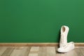 Stylish sneakers on floor near color wall