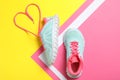 Stylish sneakers and shoe lace in shape of heart on color background, flat lay Royalty Free Stock Photo