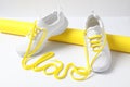 Stylish sneakers and word Love made with yellow shoe laces on white background