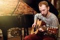 Stylish solo guitarist performing on a concert on a background o