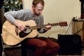 Stylish solo guitarist performing on a concert on a background o