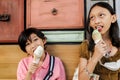 Southeast Asian children, boy and girl enjoy eating ice cream cones together at mall Royalty Free Stock Photo