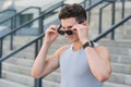 Stylish sport fashion.an looking over sunglasses. handsome guy wear sport clothes. sportsman with watch. fitness male Royalty Free Stock Photo