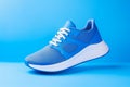 Stylish sport shoes on blue background, simple urban aesthetics. Sportswear, minimalist style and fashion, running footwear.