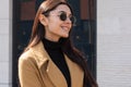 Stylish spring portrait close-up outdoors. A woman in a coat and sunglasses