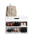 Stylish storage cabinet with different pairs of shoes and backpack on white background