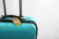Stylish suitcase with travel insurance label on background, closeup. Space for text