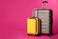 Stylish suitcases on color background