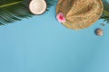 Stylish summer composition with coconut, green leaves, hat on a blue pastel background Royalty Free Stock Photo
