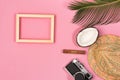 Stylish summer composition with photo frame, green leaves, hat and coconut on a blue pastel background Royalty Free Stock Photo