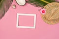 Stylish summer composition with photo frame, green leaves, hat and coconut on a pink pastel background Royalty Free Stock Photo