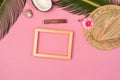 Stylish summer composition with photo frame, green leaves, hat and coconut on a pink pastel background Royalty Free Stock Photo