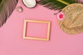 Stylish summer composition with photo frame, green leaves, hat and coconut on a pink pastel background Royalty Free Stock Photo