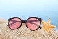 Stylish sunglasses and starfish on sandy beach Royalty Free Stock Photo