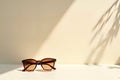 Stylish Sunglasses on Surface with Shadowy Leaf Pattern and Warm Royalty Free Stock Photo
