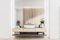 Stylish sunny eco design bathroom with wooden wall and countertop, white washbasin, rolled towels and clean light walls
