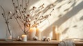 Stylish table with cotton flowers and aroma candles near light wall