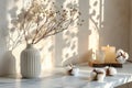 Stylish table with cotton flowers and aroma candles near light wall