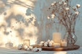 Stylish table with cotton flowers and aroma candles near light wall