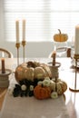 Stylish table setting with candles and autumn decor in dining room Royalty Free Stock Photo