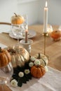 Stylish table setting with glasses, candles and autumn decor in dining room Royalty Free Stock Photo