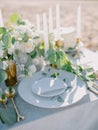 Stylish table setting with a paper card decorated with eucalyptus branches close up. Romantic table with paper invitation card. Royalty Free Stock Photo