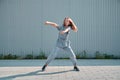 Stylish teen girl dancing hip hop outdoor on urban background. Energetic dancer performing breakdance moves Royalty Free Stock Photo