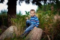 Stylish teenage boy sit on rock