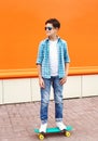 Stylish teenager boy wearing a checkered shirt, sunglasses on skateboard Royalty Free Stock Photo
