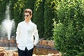 Stylish teenager 16-18 years old in sunglasses outdoors on the background of nature and a fountain. Adolescence Royalty Free Stock Photo