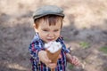 Stylish toddler boy in checkered shirt with milk moustache offering ice-cream, reaching out hand to camera. Focus on boy`s face Royalty Free Stock Photo