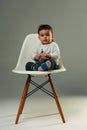 Baby is sitting on the chair in studio