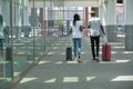 Stylish tourist black couple with suitcases walking along street near by the station and talking