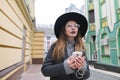 Portrait of a stylish woman listening to music in headphones on the background of the old town. Royalty Free Stock Photo