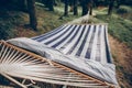 Stylish travel hammock in blue white colors in summer sunny park. resting, camping and relaxing outdoor, summer vacation and