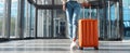 The stylish traveler with an orange suitcase in a modern airport setting. AI generated image Royalty Free Stock Photo