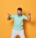 Stylish trendy gray-haired hipster guy dancing and having fun on bright orange background. Royalty Free Stock Photo