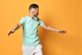 Stylish trendy gray-haired hipster guy dancing and having fun on bright orange background. Royalty Free Stock Photo