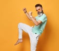 Stylish trendy gray-haired hipster guy dancing and having fun on bright orange background. Royalty Free Stock Photo