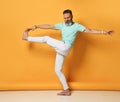 Stylish trendy gray-haired hipster guy dancing and having fun on bright orange background. Royalty Free Stock Photo
