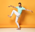 Stylish trendy gray-haired hipster guy dancing and having fun on bright orange background. Royalty Free Stock Photo