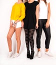 Stylish Trio: Three Young and Gorgeous Women Strike a Pose in Studio against White Backdrop in Modern Outfits
