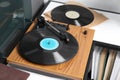 Stylish turntable with vinyl disc on table in room, closeup Royalty Free Stock Photo